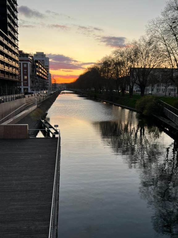 une rivière dans une ville avec un coucher de soleil en arrière-plan dans l'établissement Mandana, à Strasbourg