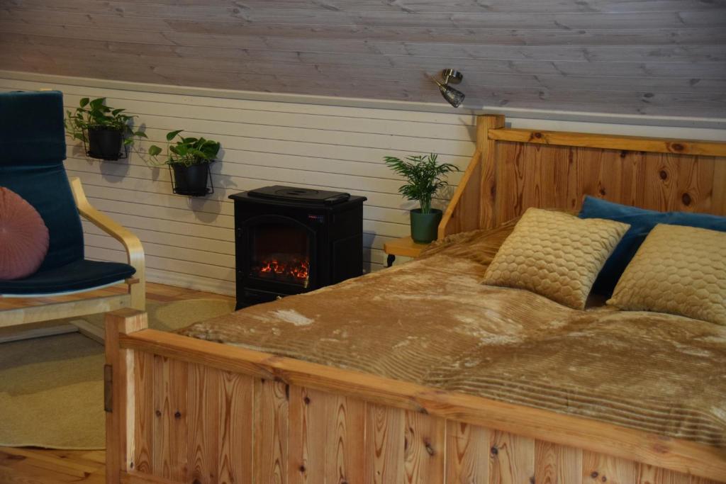 een slaapkamer met een bed en een houtkachel bij Čučumuiža in Kuldīga