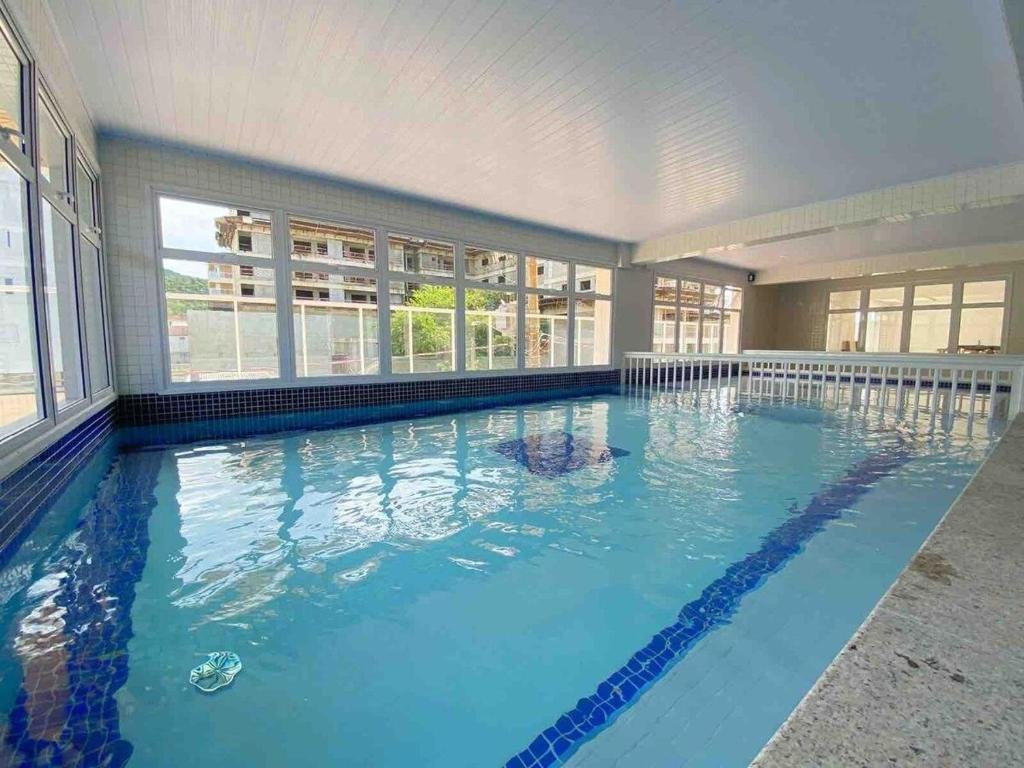 a large swimming pool with blue water in a house at Ubatuba- Praia das Toninhas 104. in Ubatuba