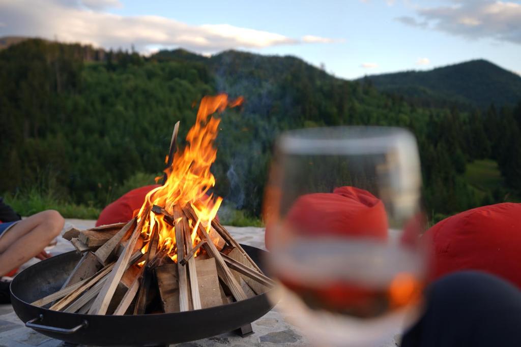 a glass of wine next to a fire pit at NICA Chalet in Fundata