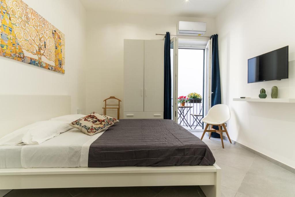 a white bedroom with a bed and a tv at Nena Sweet Home in Palermo