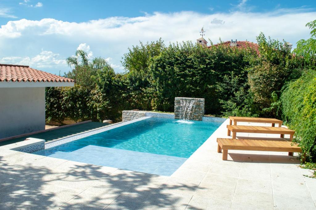 una piscina con un banco de madera y un banco en Casa en centro de Carlos Paz con pileta en Villa Carlos Paz