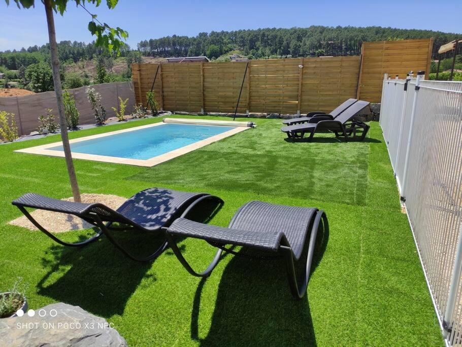 a yard with chairs and a swimming pool at L&#39;Odyssée gîte avec sa piscine privative in Joyeuse