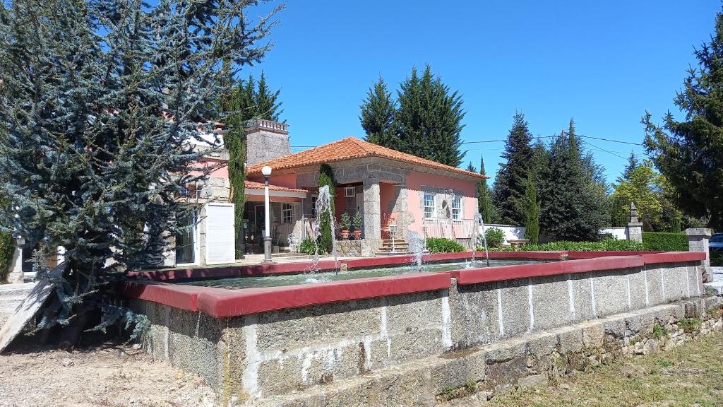 a brick wall with a fountain in front of a house at Casa do Lobo in Lamego