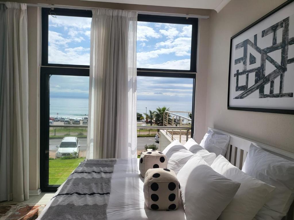 a living room with a white couch and a large window at 13 at Santos in Mossel Bay