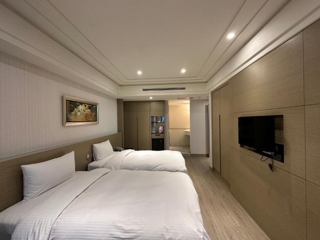 a hotel room with two beds and a flat screen tv at Link World Hotel in Taipei