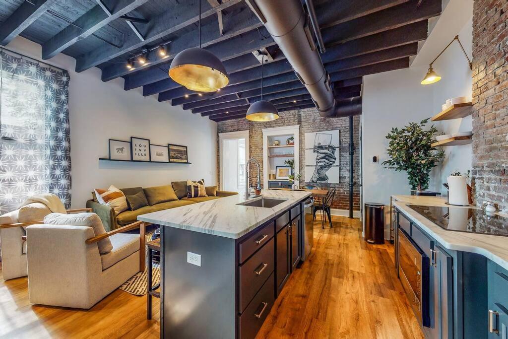 a kitchen and living room with a couch and a table at Luxury 8 Bed/4 Ba NuLu Home Private yard/parking in Louisville