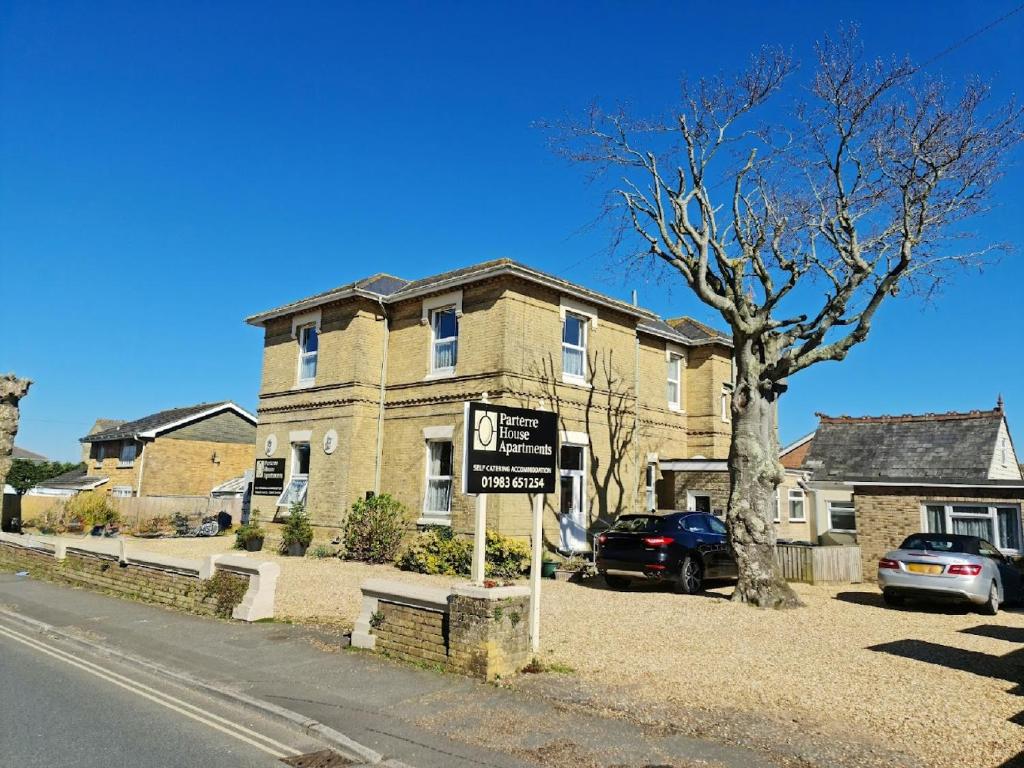 une maison avec un panneau devant elle dans l'établissement Parterre Holiday Apartments, à Sandown