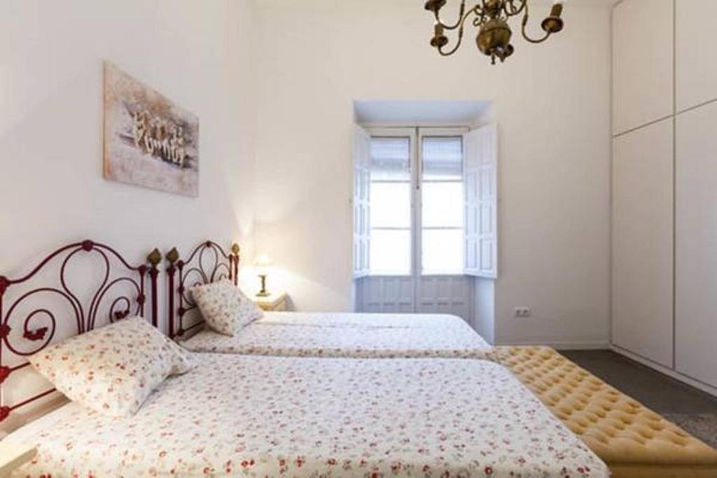 a bedroom with two beds and a window at Apartamentos RG Arenal in Seville