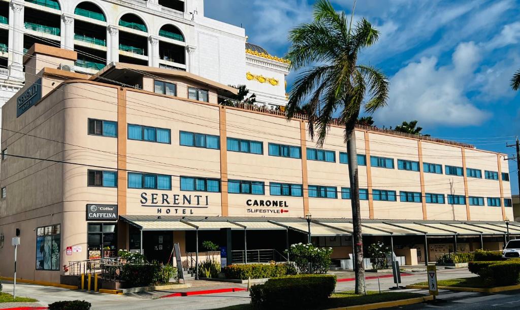 a building with a palm tree in front of it at Serenti Hotel Saipan in Garapan