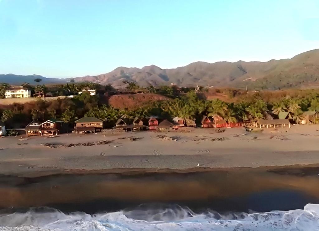 a view of a beach with houses and mountains at Nexpa cabañas Martha surf spot in Caleta de Campos