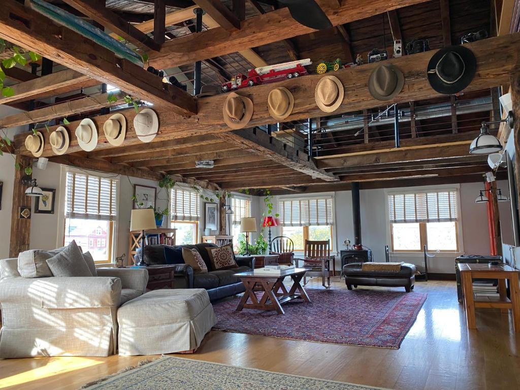 a living room with a lot of furniture and wooden ceilings at Magical Post And Beam Loft Downtown Newport! in Newport