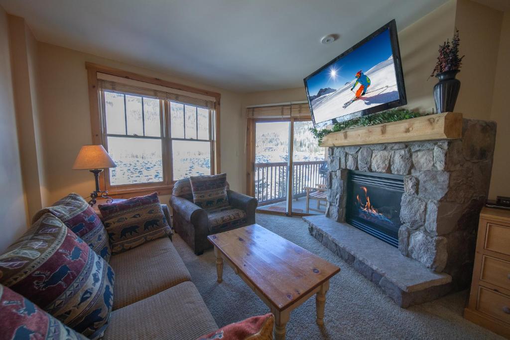 a living room with a television above a fireplace at Buffalo Lodge 8381 in Keystone
