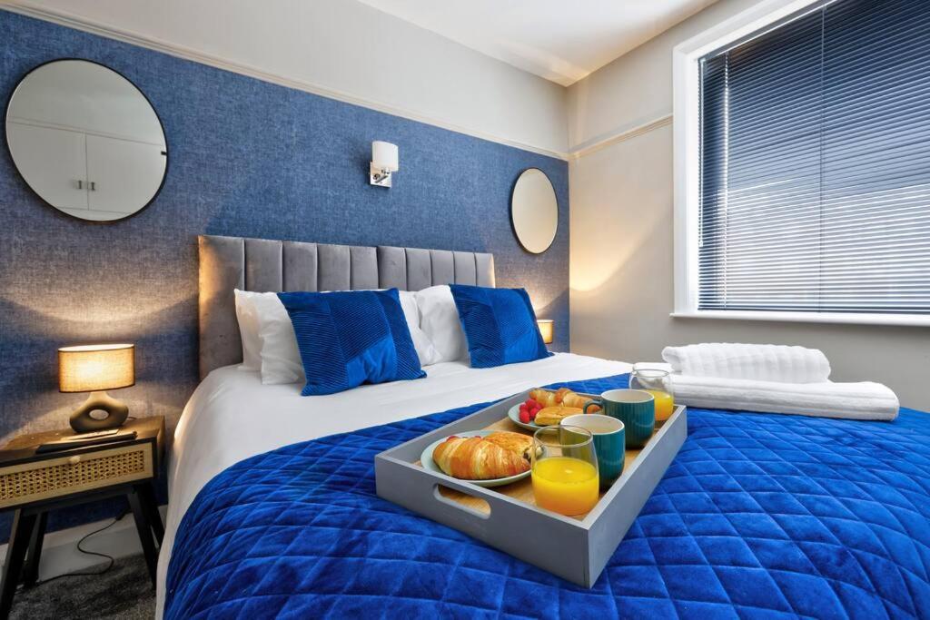 a bedroom with a bed with a tray of food on it at Deluxe king seaside apartment in Bare