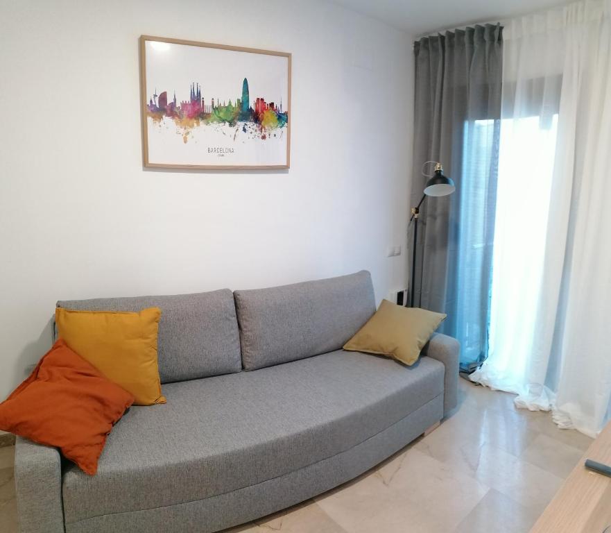 salon z szarą kanapą z poduszkami w obiekcie Piso pl 2A, 20 min Plaza Cataluña w mieście Sant Adria de Besos