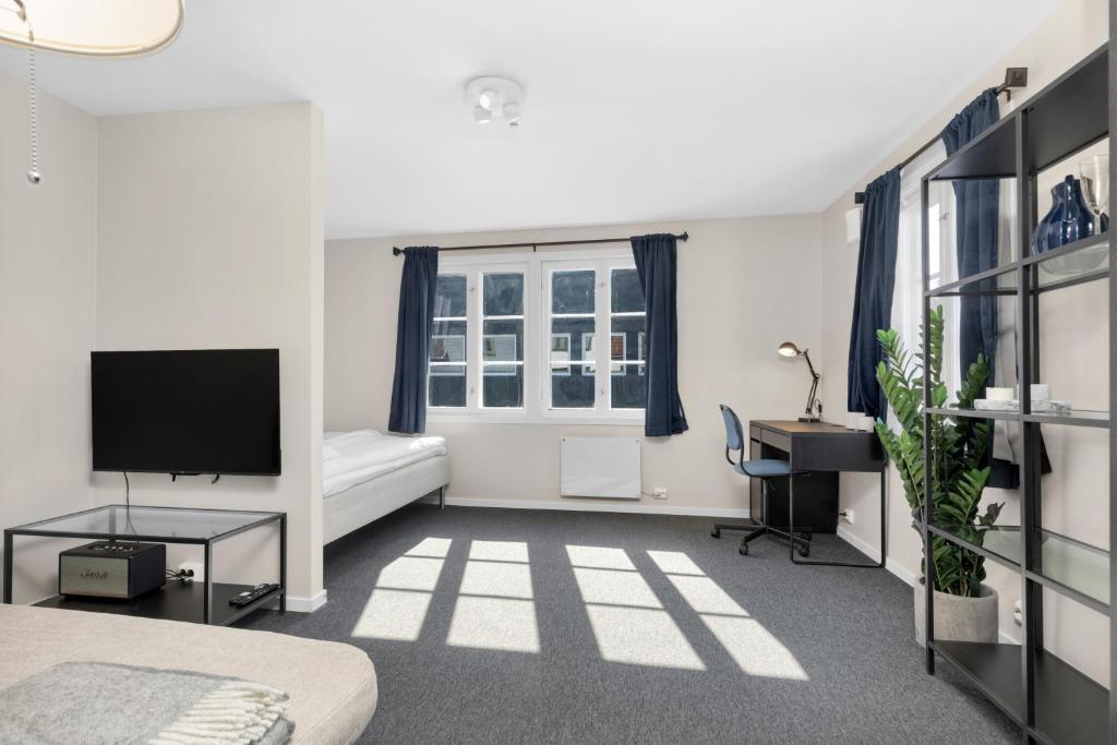 1 dormitorio con 1 cama, escritorio y TV en Central Studio Apartment in Stavanger en Stavanger