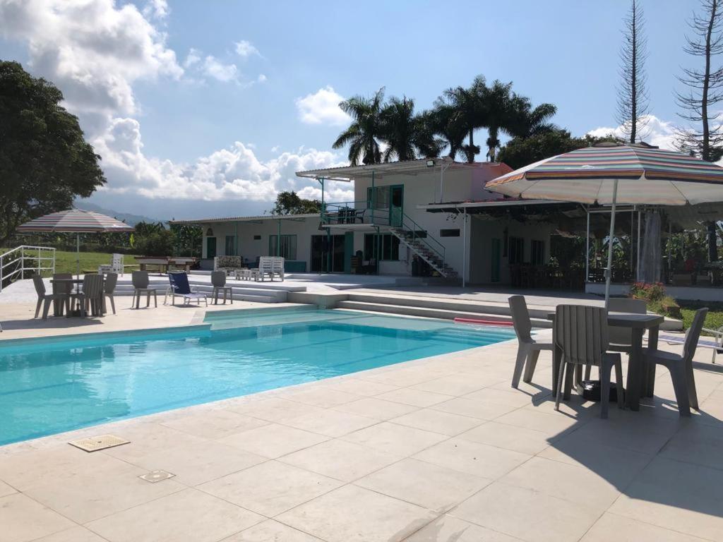 卡拉爾卡的住宿－La Bella Vista，一个带椅子和桌子的游泳池以及一把遮阳伞