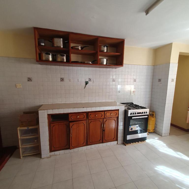 uma cozinha com armários de madeira e um fogão em Château Lake-ish em Nakuru