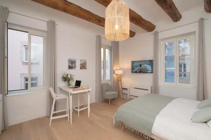a bedroom with a bed and a desk with a laptop at Design Suites Vieux Port in Marseille