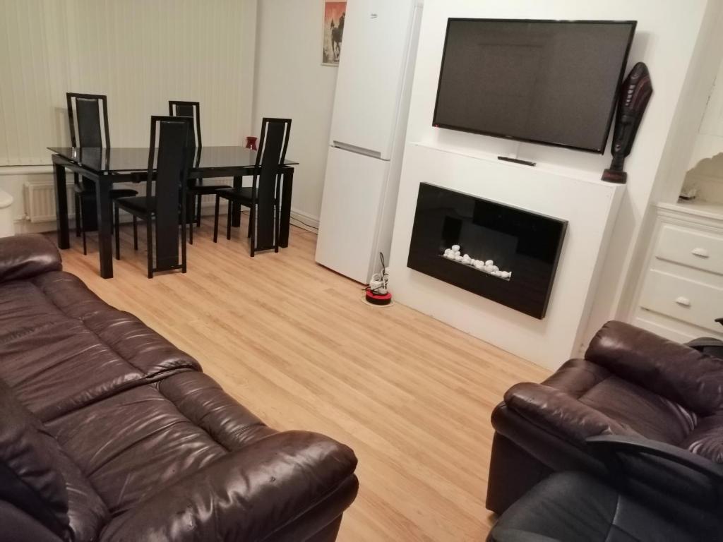 a living room with a couch and a table with a fireplace at Spacious Room near Manchester City Centre in Manchester
