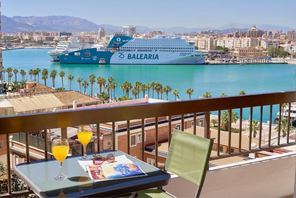 balkon ze stołem i statkiem wycieczkowym na wodzie w obiekcie Impresionante apartamento en Playa de la Malagueta w Maladze