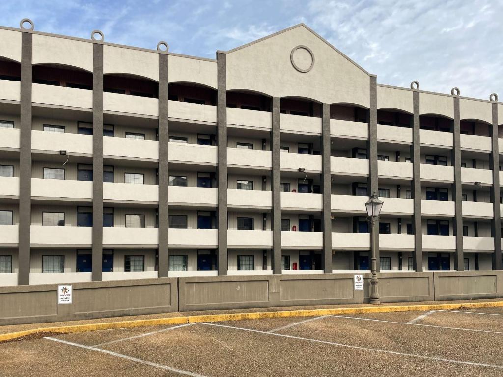 ein großes weißes Gebäude mit Parkplatz davor in der Unterkunft Studio 6 Vicksburg, MS- Downtown in Vicksburg
