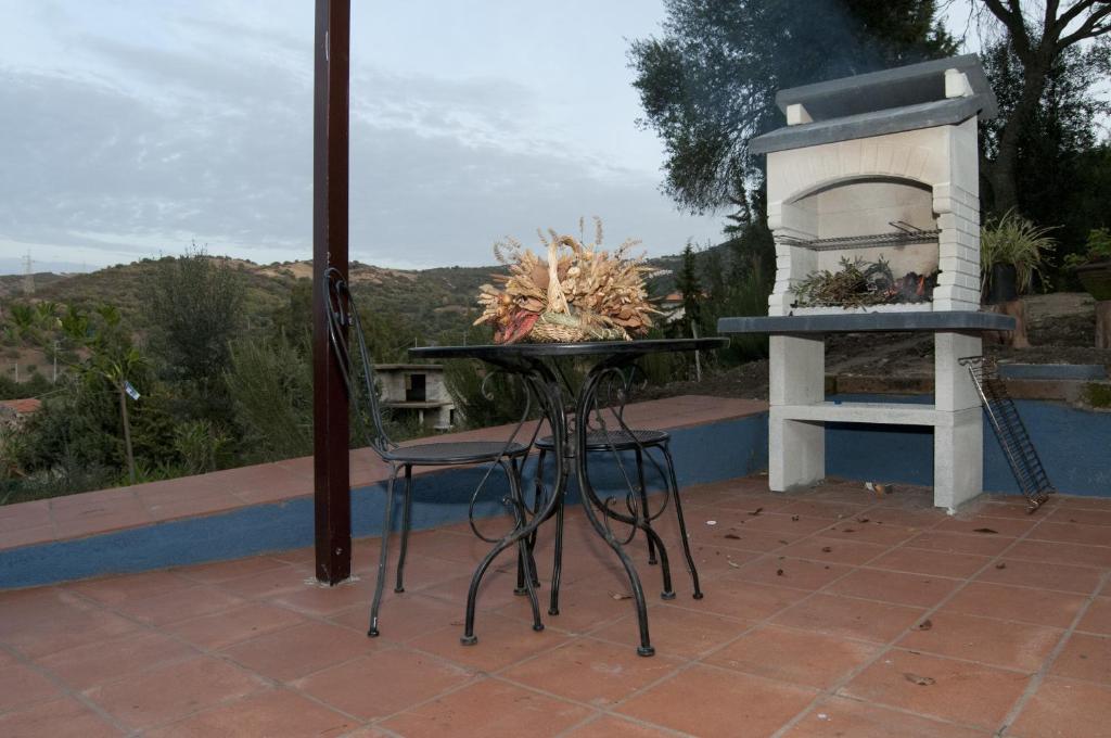 a table and chairs on a patio with a fireplace at B&B Santu Larentu in Ozieri