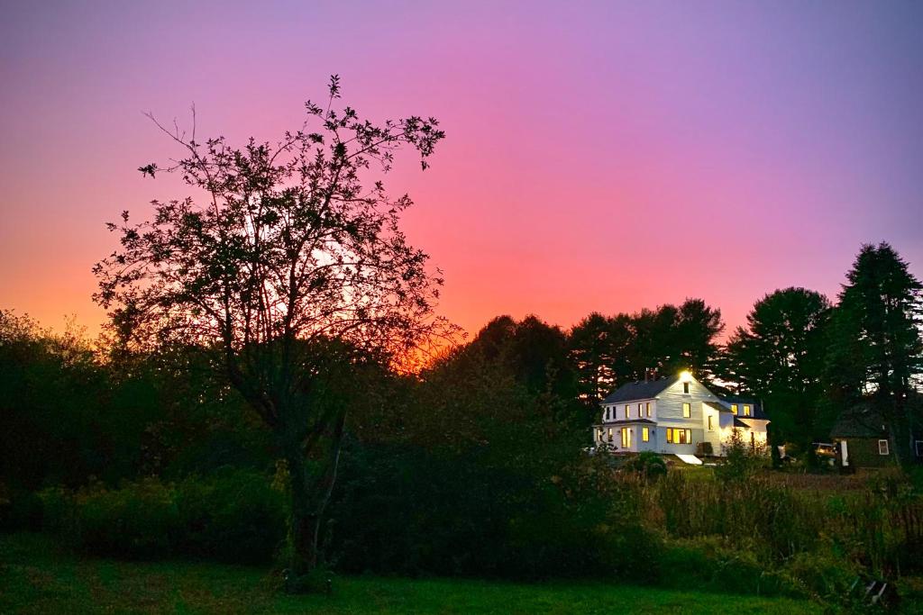 una casa con un árbol delante de una puesta de sol en Wild Rose Farm, en Kennebunkport