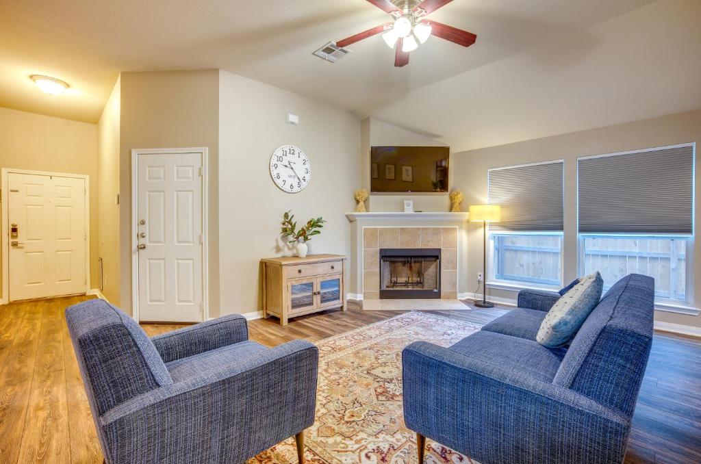 a living room with two blue chairs and a fireplace at Pet-Friendly Texas Retreat with Fenced-In Yard! in Bryan