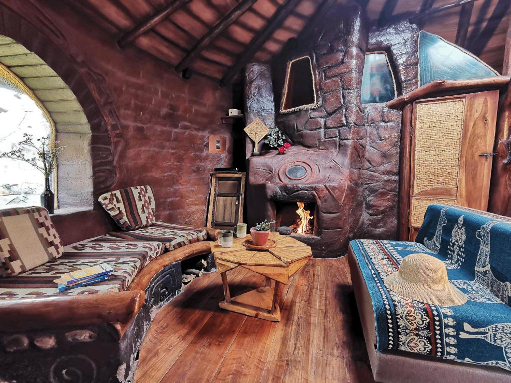 uma sala de estar com um sofá e uma lareira de pedra em La Choza - Casa Suaya La Esperanza em Ibarra