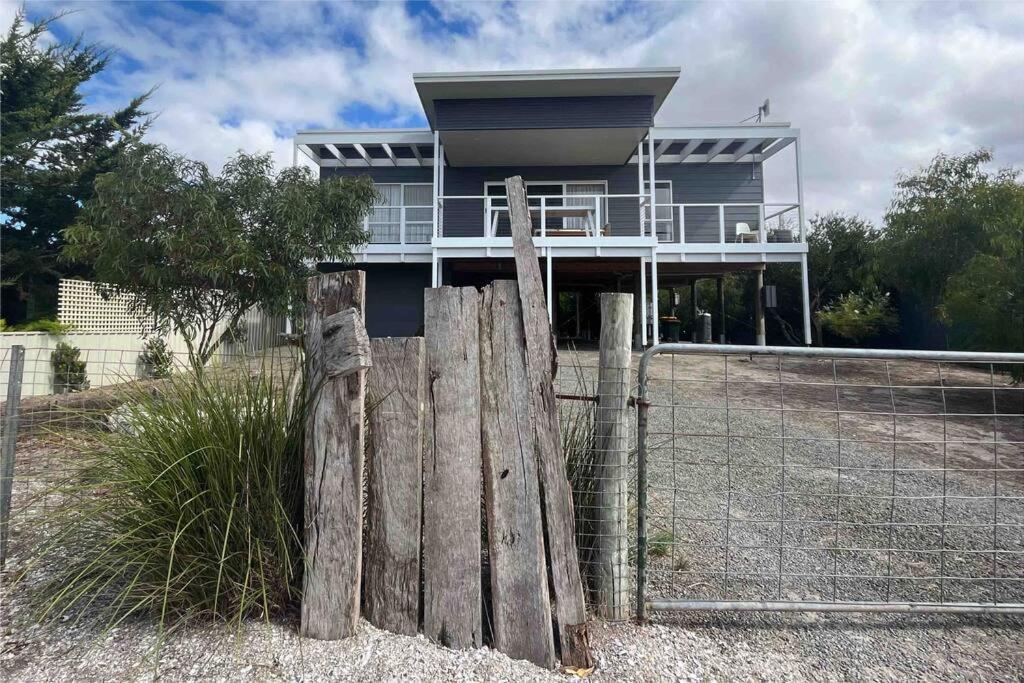 a wooden fence in front of a house at Beachfront 4 Bedroom Home in Nepean Bay in Nepean Bay