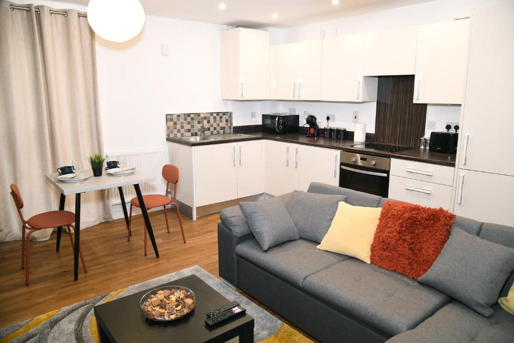 a living room with a couch and a kitchen at Crayford, Super Cosy 2-Bed Apartment in Dartford