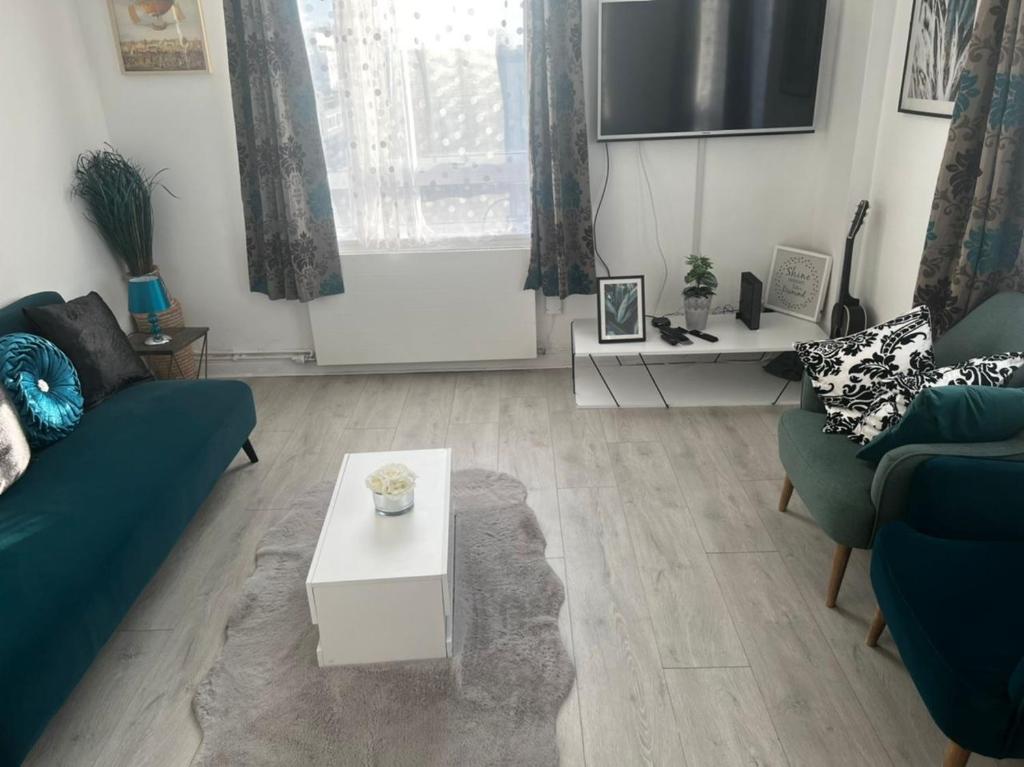 a living room with two couches and a table at 13 Clifton Court - Lovely 2 bedroom flat with patio in Finsbury Park in London