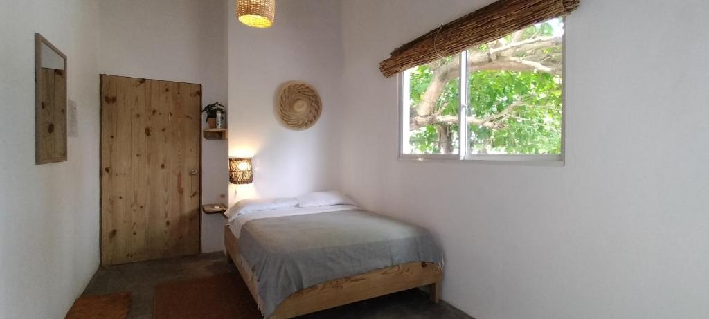 a small bedroom with a bed and a window at Kite House Cabarete across Kite Beach in Cabarete