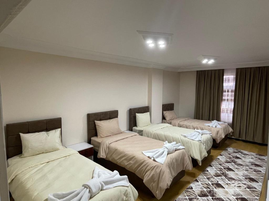 ein Zimmer mit 3 Betten und Handtüchern darauf in der Unterkunft Eyüpsultan ABS Suites in Istanbul