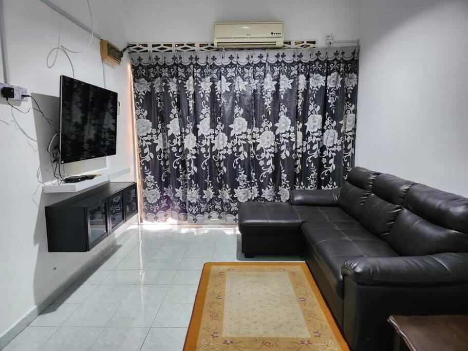 uma sala de estar com um sofá de couro e uma televisão em D'Haja 6 KLIA Sepang with 3 AC & FREE Wi-Fi em Banting