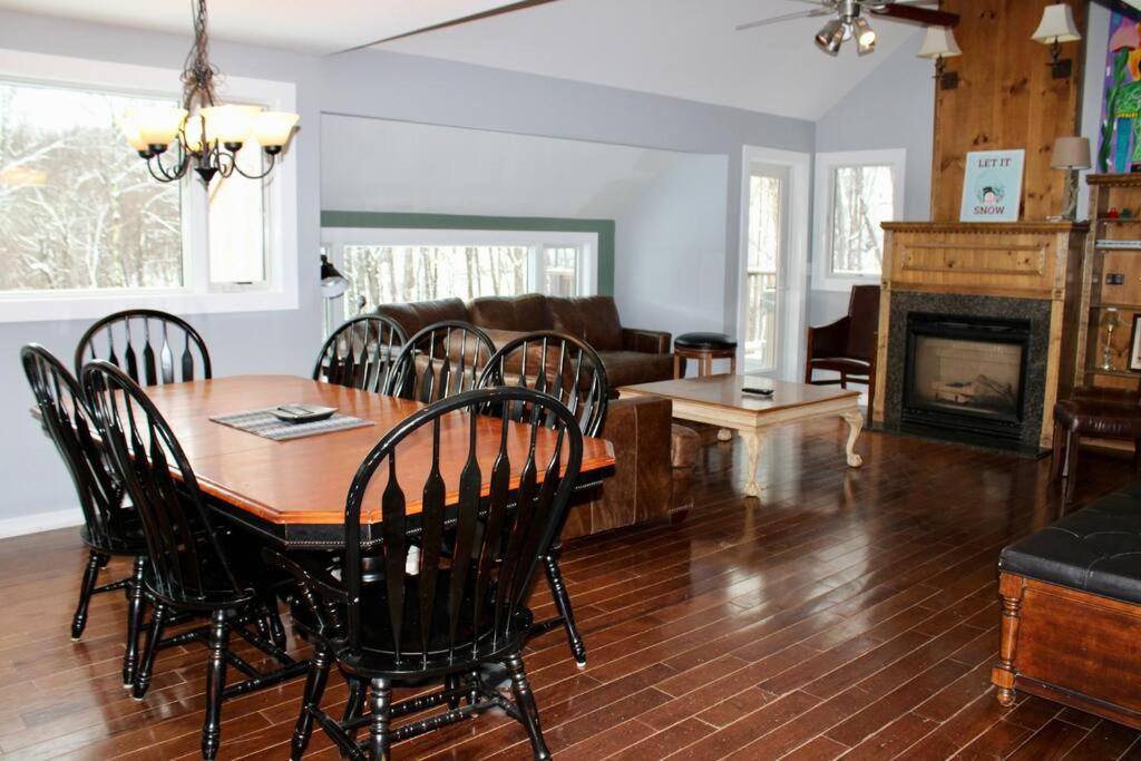 a dining room and living room with a table and chairs at Condo 4 with AC Sauna and Hot tub Slopeside in the Winter in Killington