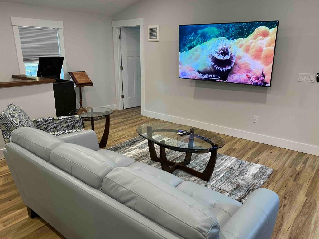 a living room with a couch and a tv on a wall at Modern 2BR 2BA with King bed-Fast Wi-Fi 75 inch OLED TV in Wilmington