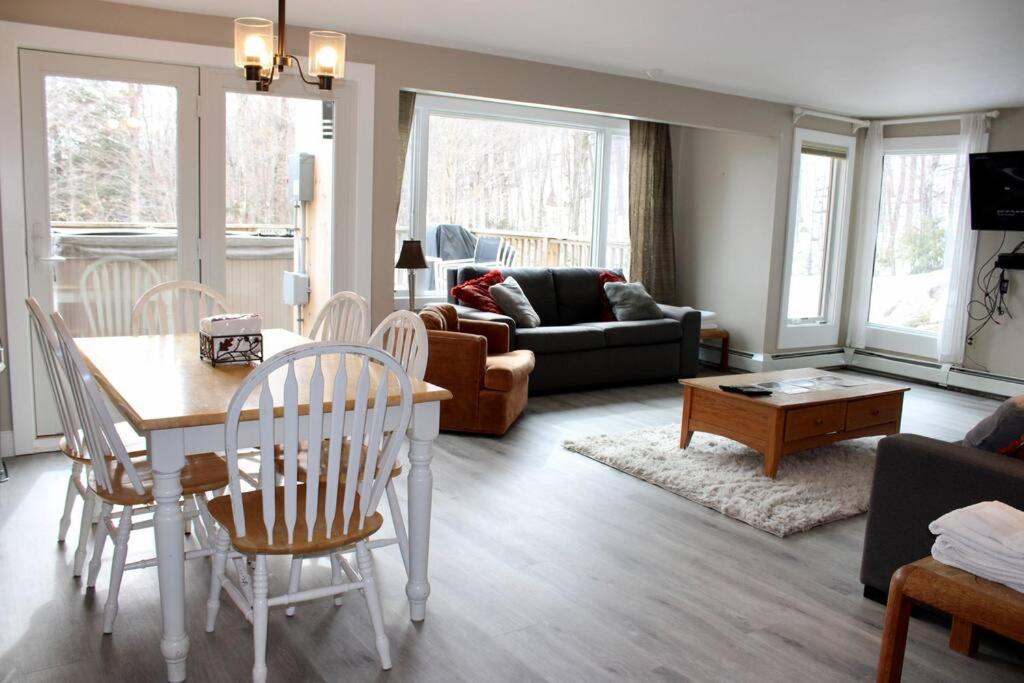 un salon avec une table, des chaises et un canapé dans l'établissement Condo #5 Slopeside One Bedroom with Sauna and Hot tub, à Killington