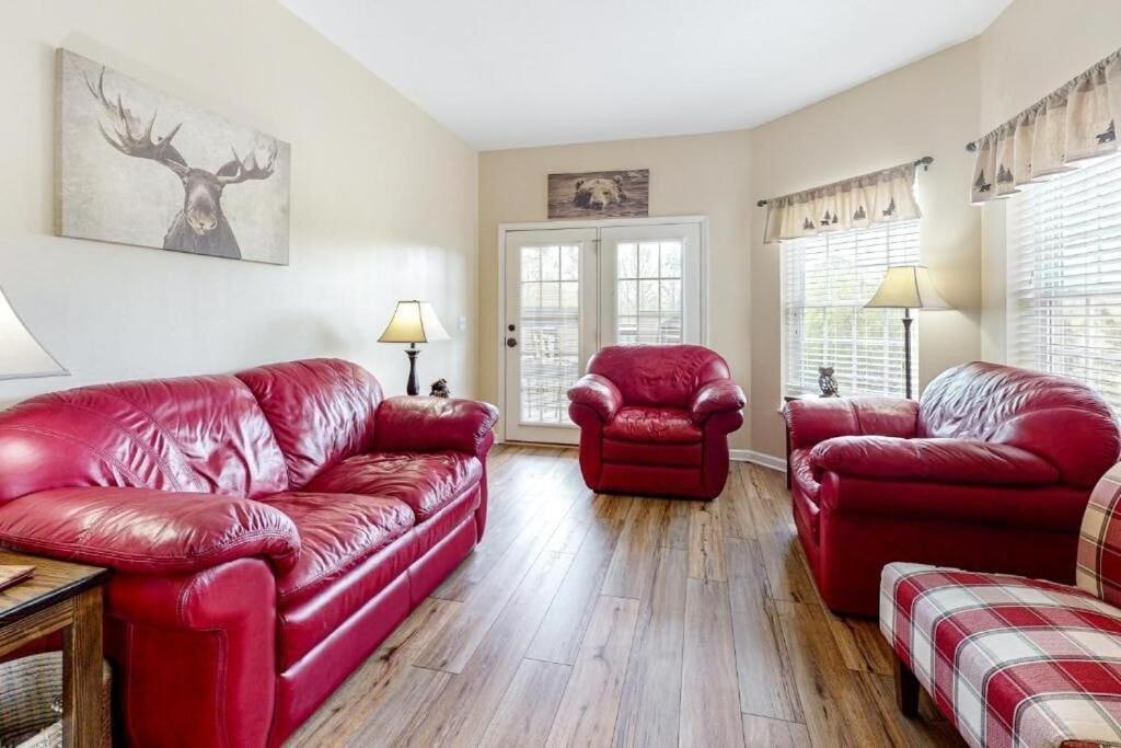 uma sala de estar com sofás de couro vermelho e cadeiras em Bandit's Riverfront Retreat - Mountain View- Condo-Fishing-Balcony-Fireplace-Great Location! em Pigeon Forge