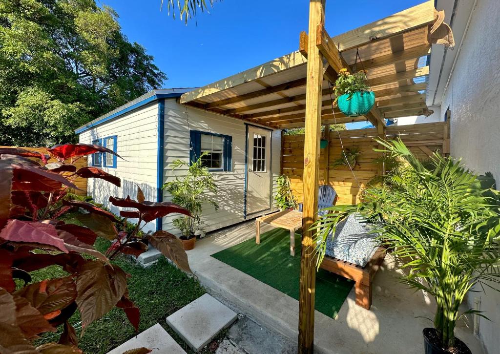 a tiny house with a pergola in a garden at Beach guests house in Miami