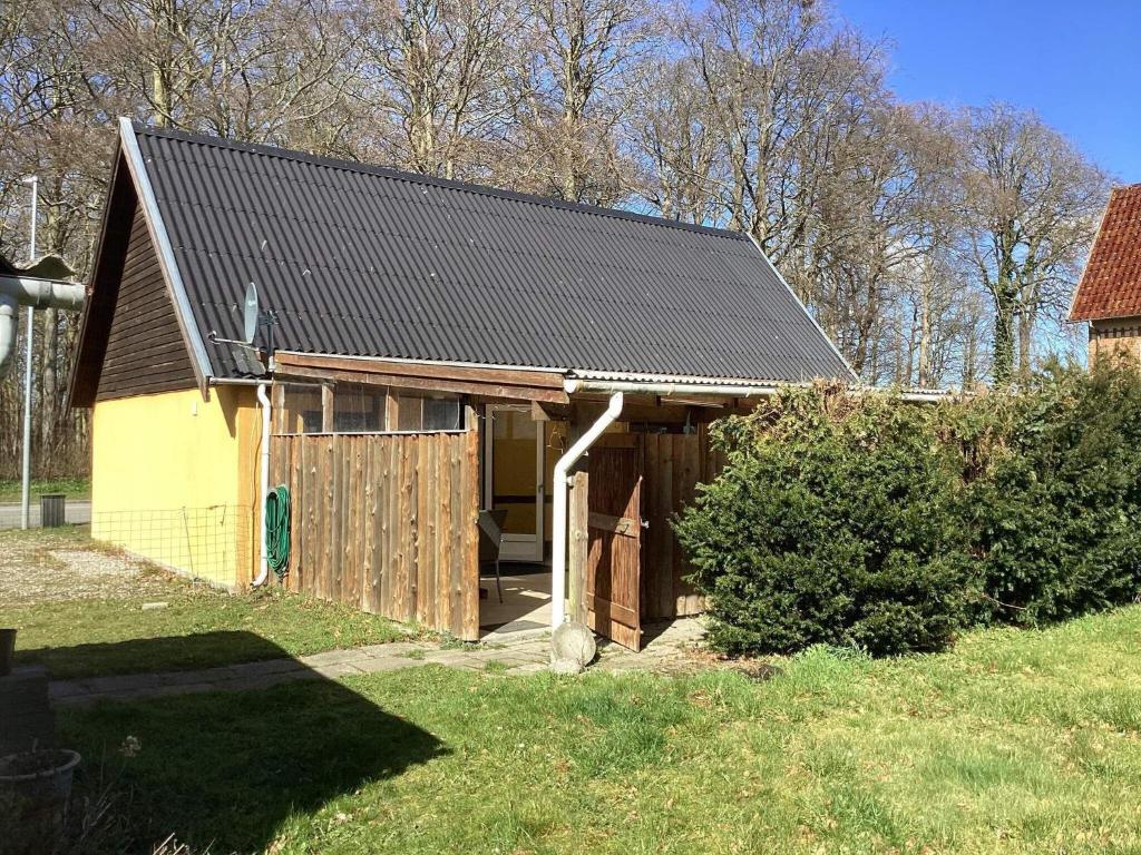 a barn with a gambrel roof on a yard at Holiday home Rødby III in Rødby