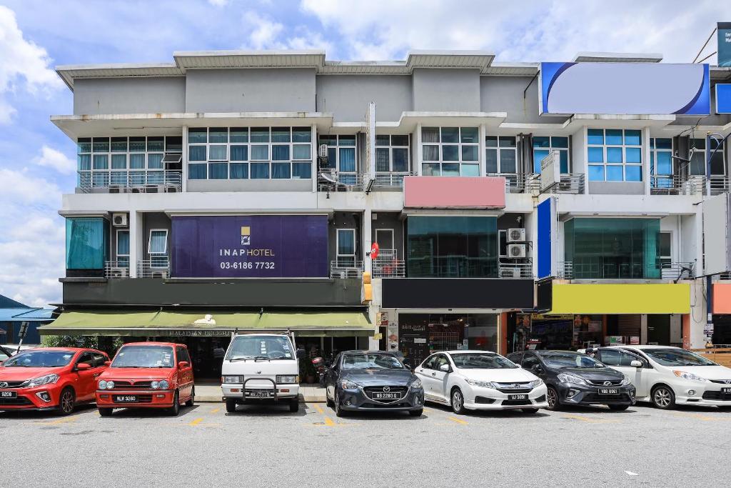 a large building with cars parked in a parking lot at Hotel Inap in Batu Caves