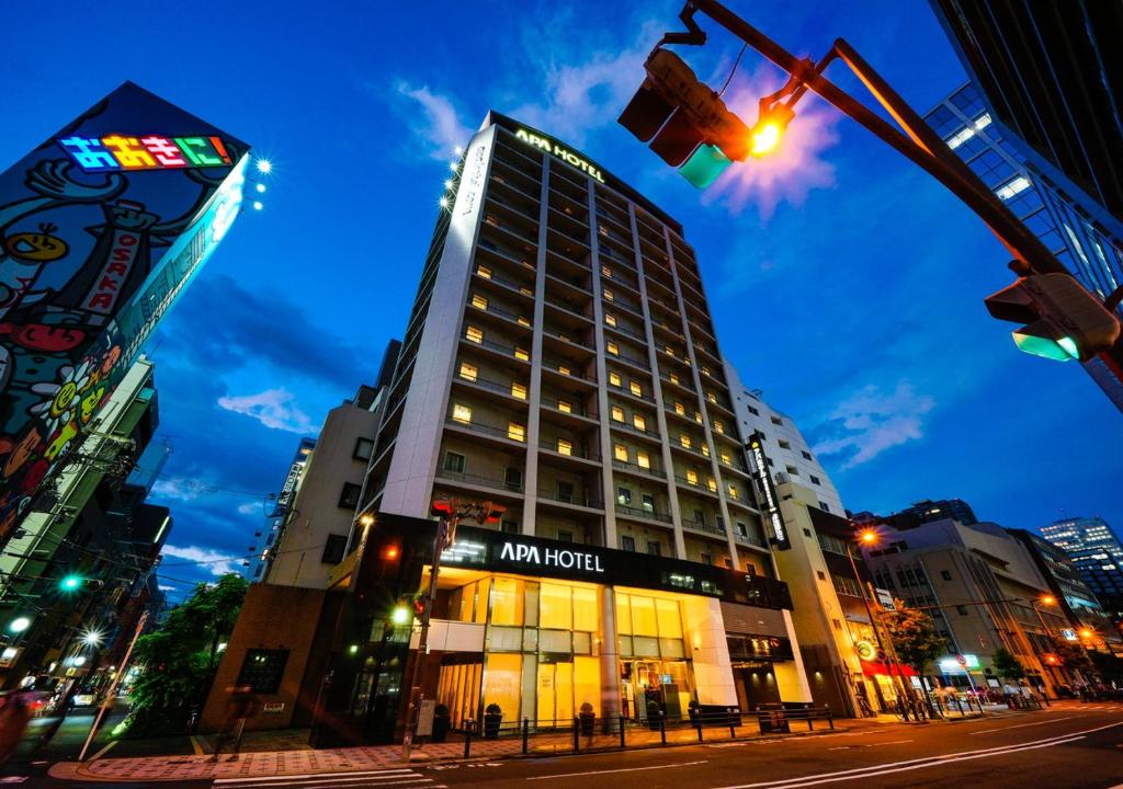 ein hohes Gebäude in der Nacht auf einer Stadtstraße in der Unterkunft APA Hotel Midosuji-Honmachi-Ekimae in Osaka