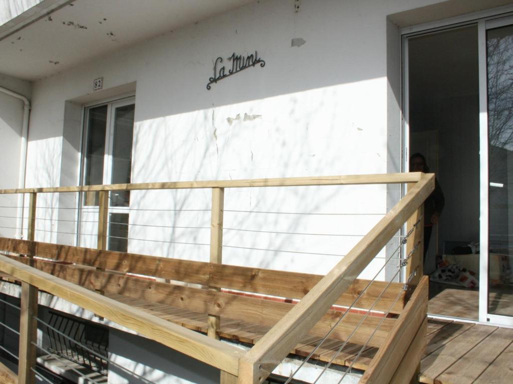 une terrasse avec une rampe en bois devant un bâtiment dans l'établissement Maison spacieuse à 400m de la plage - FR-1-22-222, à La Tranche-sur-Mer