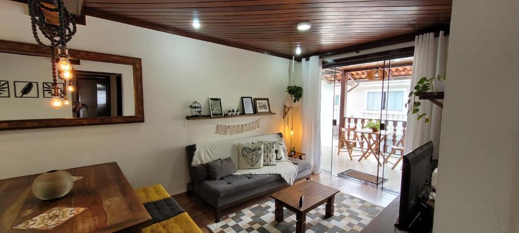 un soggiorno con divano e tavolo di Hospedagem Doce Lar - Casa Bougainville a Teresópolis