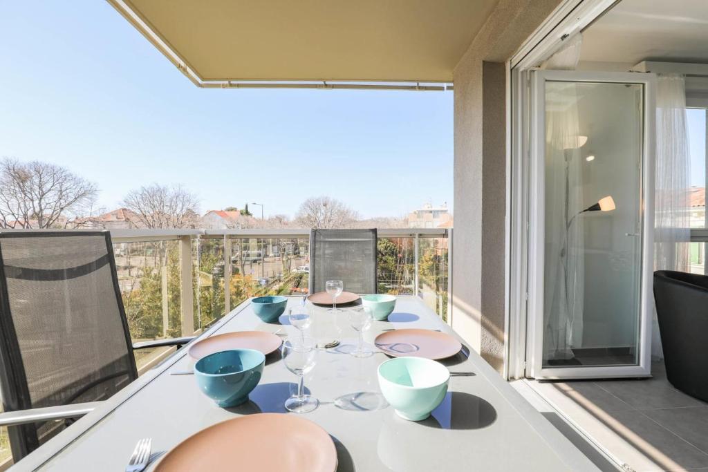 - une table avec des verres à vin sur le balcon dans l'établissement Le Michelet - Appart 2 ch avec terrasse et parking, à Marseille