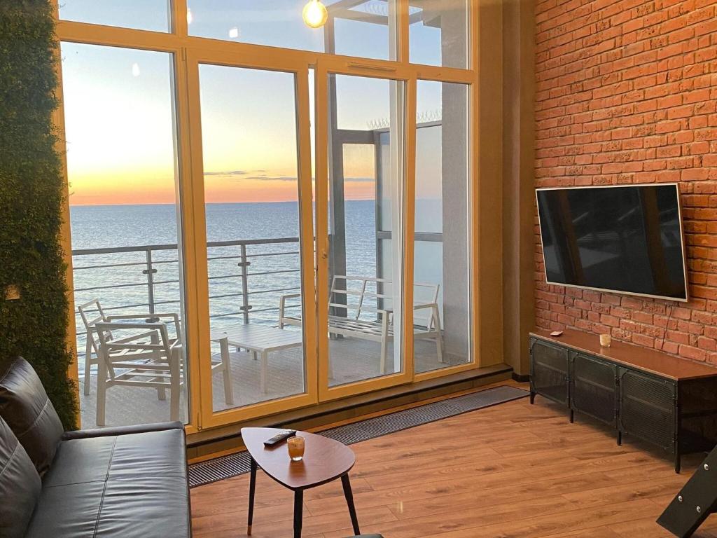 uma sala de estar com vista para o oceano em Penthouse for 4 people with sea view em Dziwnówek