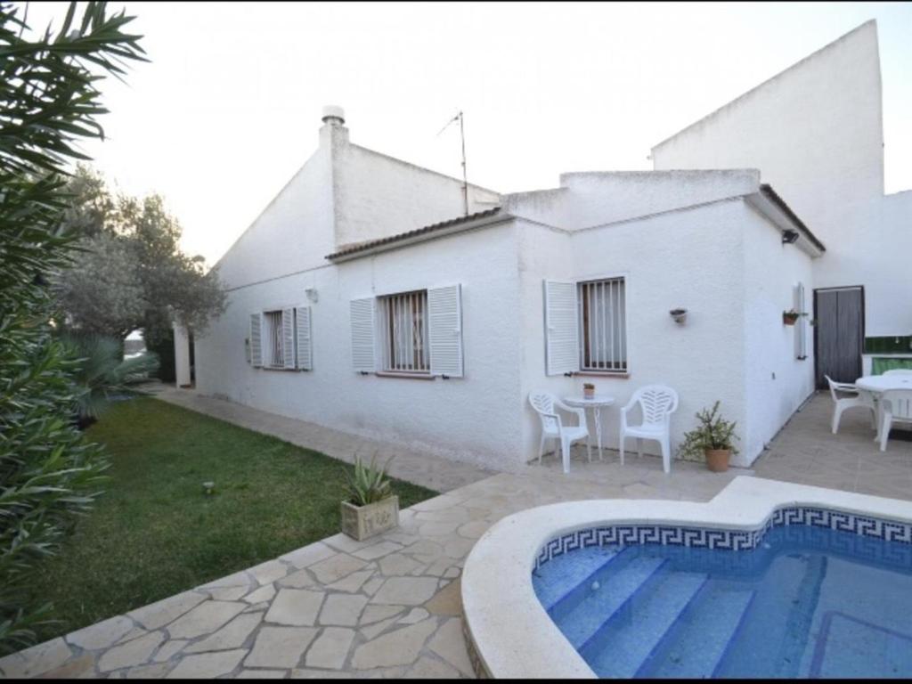 une maison blanche avec une piscine dans la cour dans l'établissement Villa L'Ametlla de Mar, 3 dormitorios, 7 personas - ES-221-14, à L'Ametlla de Mar