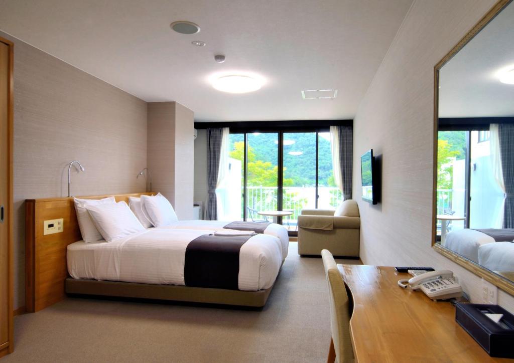 een hotelkamer met een bed, een tafel en een bureau bij Hatago Nagomi in Nikko